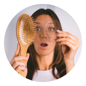 Mulher segurando a escola de cabelo e espantada com a queda de cabelo.