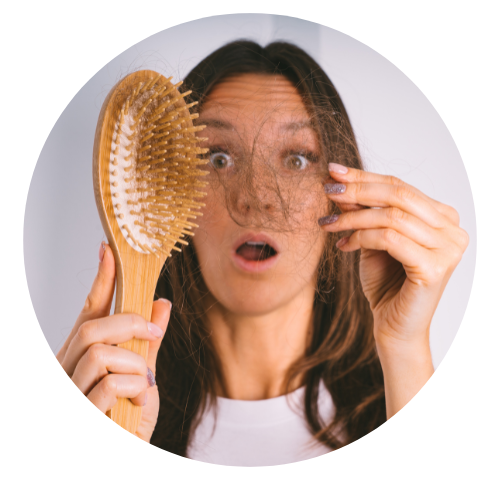 Mulher segurando a escola de cabelo e espantada com a queda de cabelo.