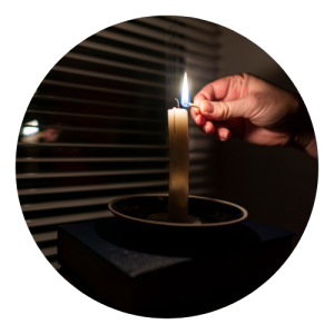 homem acende uma vela durante um apagão em sua casa.