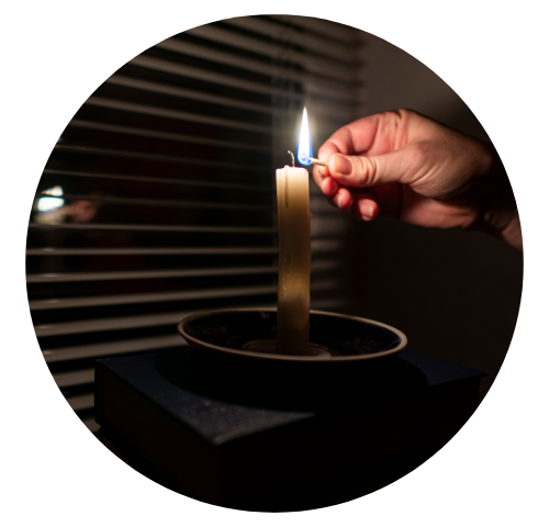 homem acende uma vela durante um apagão em sua casa.