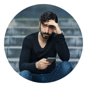 Homem está sentado em uma escada, olhando para o celular e com semblante preocupado. A medicina tradicional chinesa trata essa sensação.