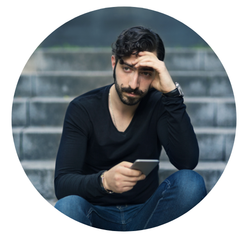 Homem está sentado em uma escada, olhando para o celular e com semblante preocupado. A medicina tradicional chinesa trata essa sensação.