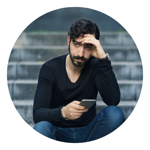 Homem está sentado em uma escada, olhando para o celular e com semblante preocupado. A medicina tradicional chinesa trata essa sensação.